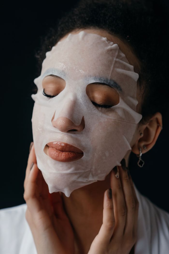 Close-up portrait of a woman enjoying a skincare treatment with a nourishing sheet mask.